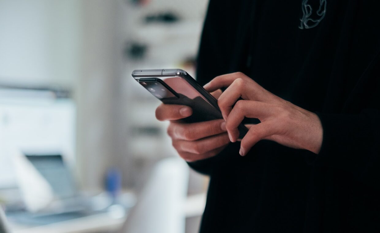 Hands holding phone, photographed for a technology article.