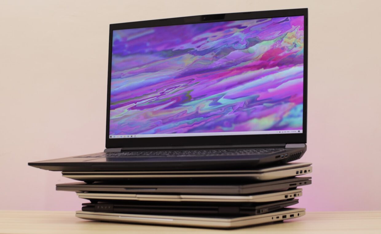 Old laptops stacked, photographed for a technology article.